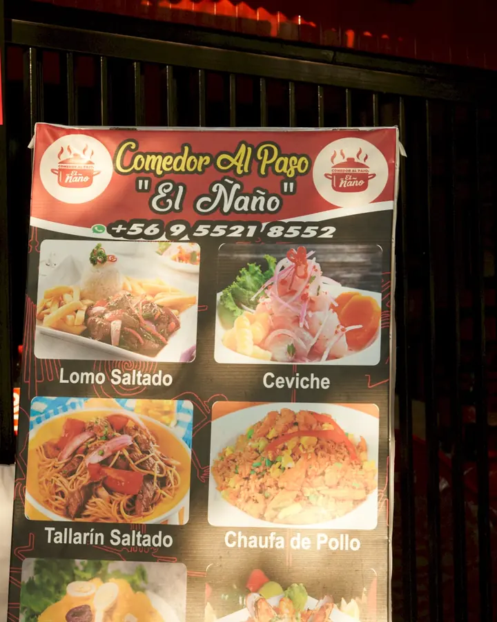 Letrero del Comedor al Paso El Ñaño en la vereda de noche
